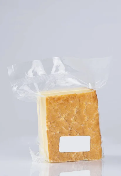 Mavi Arka Planda Plastik Bir Torba Içinde Dikey Bir Peynir — Stok fotoğraf