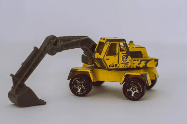 白い背景に黒と黄色の風化した建設機械のおもちゃのクローズアップ画像 — ストック写真