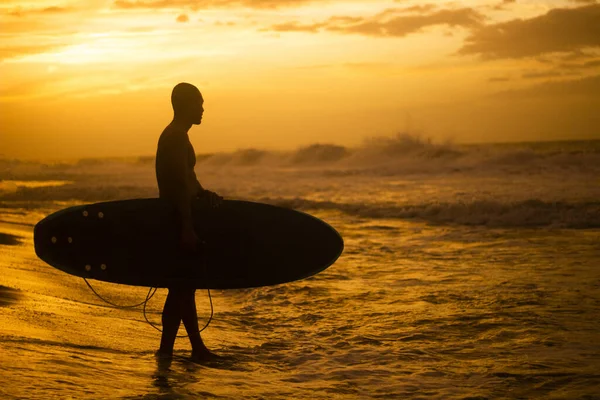 一个西班牙滑板手在日落时拿着滑板的轮廓 — 图库照片