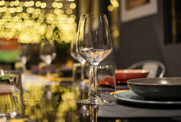 餐厅里餐具旁边一只空杯子的浅浅的焦点 — 图库照片