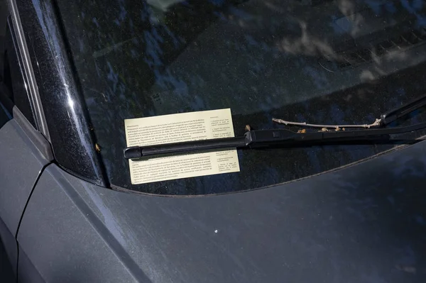 A traffic ticket in a car for badly parked on the street
