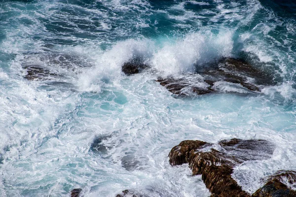 一个特写的海浪拍打在岩石上 — 图库照片