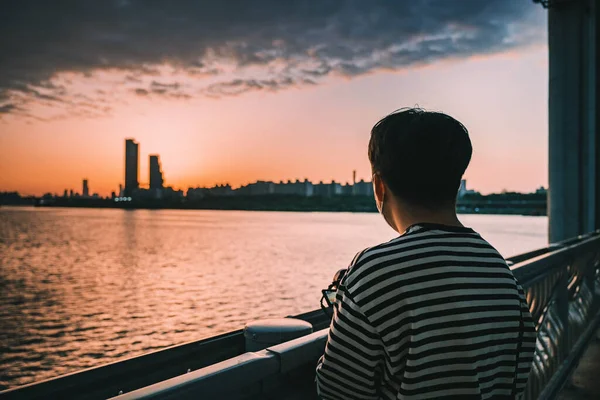 Ένας Νεαρός Άνδρας Στέκεται Στη Γέφυρα Και Απολαμβάνει Ηλιοβασίλεμα — Φωτογραφία Αρχείου