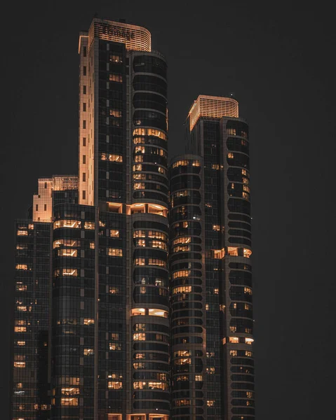 Eine Vertikale Aufnahme Eines Beleuchteten Wolkenkratzers Der Nähe — Stockfoto