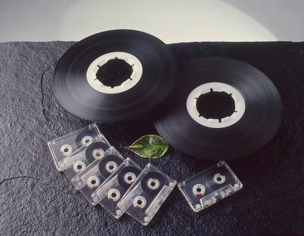 A selective focus shot of magnetic tapes and cassettes on a black surface