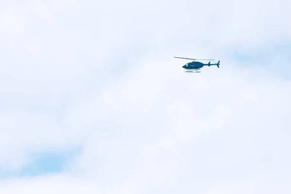 Blauer Hubschrauber Fliegt Einem Weißen Bewölkten Und Sonnigen Himmel Über — Stockfoto