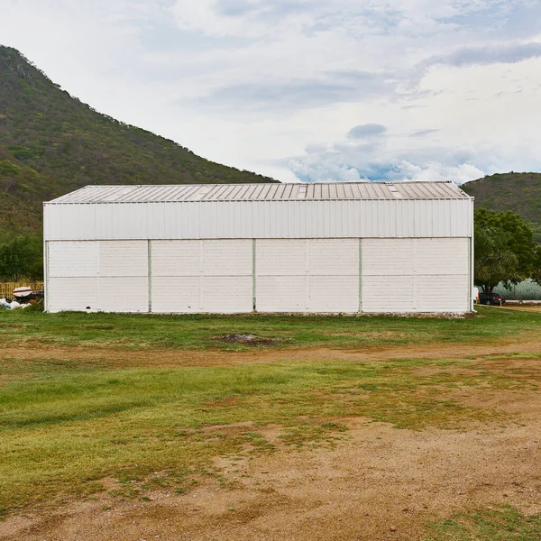 非常に美しい空の丘の近くのフィールド内に製品を保管して製造する倉庫 — ストック写真