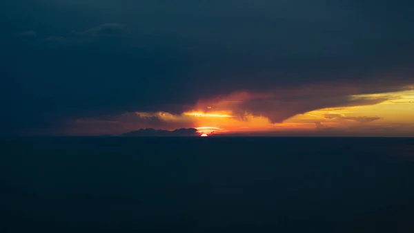 美丽的落日笼罩着静谧的大海 布满了云彩和橙色的天空 — 图库照片