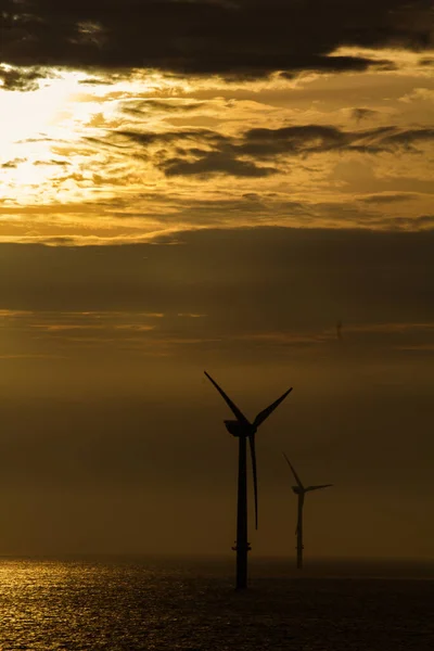 傍晚时分海面上的一个垂直的风力涡轮机镜头 — 图库照片