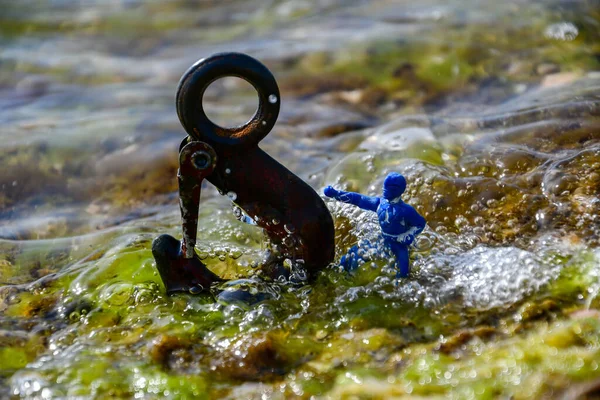Una Figura Plástico Azul Con Una Mano Extendida Junto Gancho — Foto de Stock