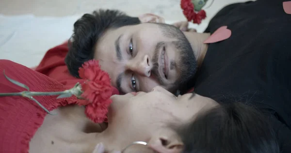 Young Indian Couple Lying Head Head Bed While Holding Flowers — 스톡 사진
