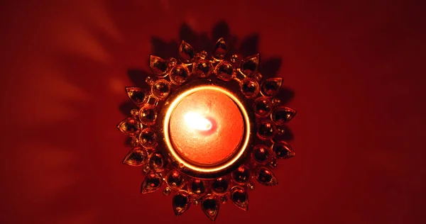 Ένα Αναμμένο Κερί Στη Διακοσμημένη Βάση Κηροπήγιο Στο Σκούρο Κόκκινο — Φωτογραφία Αρχείου