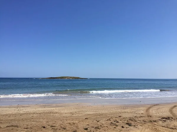 Una Spiaggia Vuota Sotto Cielo Azzurro Con Isolotto Lontananza — Foto Stock