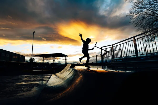 Imagem Silhueta Menino Montando Scooter Parque Skate Saltando Rampa Pôr — Fotografia de Stock