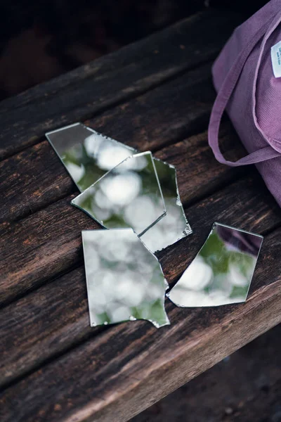 Een Verticaal Shot Van Gebroken Spiegelstukken Een Houten Bank Buurt — Stockfoto