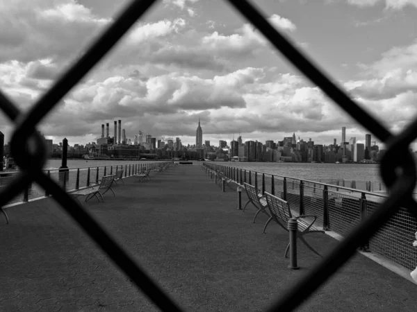 一条小径的灰度 穿过铁链篱笆望着城市 — 图库照片