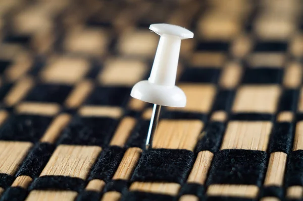 stock image A close-up photo of a white push pin fixed in a surface