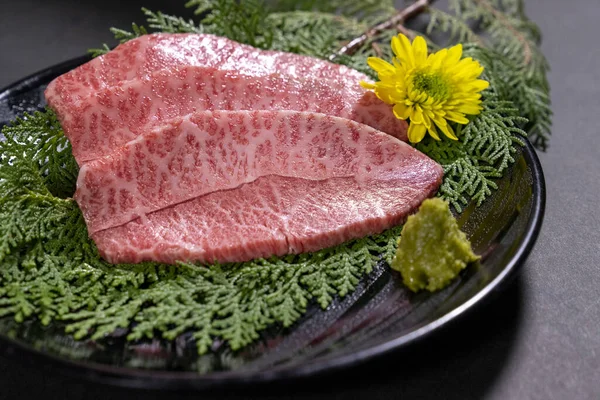 Tahtadaki Yeşil Yapraklı Çiğ Wagyu Bifteği Dilimlerinin Yakın Çekimi — Stok fotoğraf