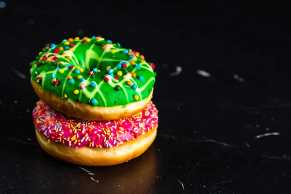 Frische Leckere Farbige Donuts Mit Streusel Auf Schwarzem Hintergrund — Stockfoto