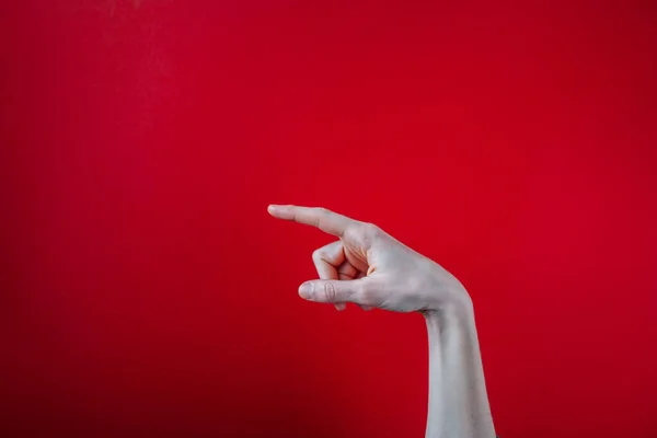 一只手用手指指向红色背景的特写镜头 — 图库照片