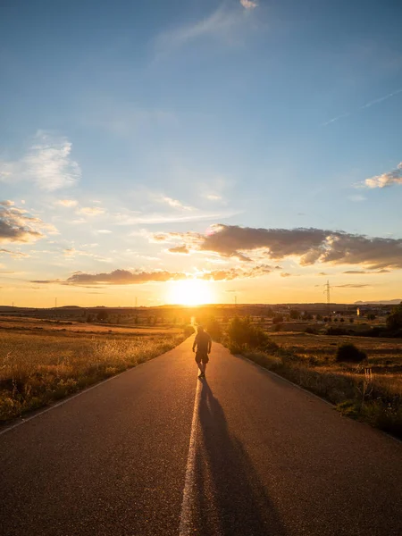 Vertical Shot Strong Man Walking Road His Back Facing Sunset — Stock Photo, Image