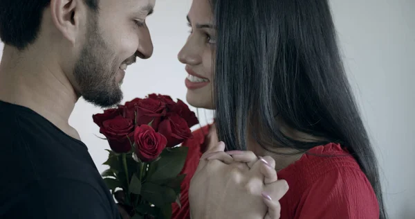 一对印度夫妇紧紧地抱着美丽的红花 在家里度过浪漫的时光 — 图库照片