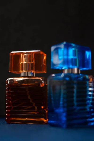 Vertikální Záběr Oranžové Modré Parfémy Láhve Tmavém Pozadí — Stock fotografie