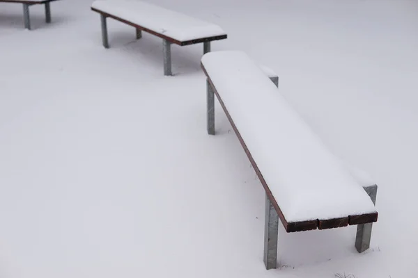 冬に雪に覆われた公園のベンチのショット — ストック写真