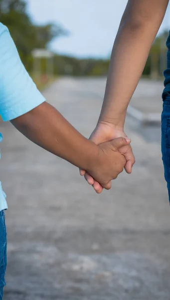 Plano Vertical Dos Hermanos Latinos Tomados Mano Con Fondo Borroso —  Fotos de Stock