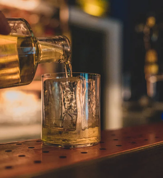 Closeup Shot Whiskey Pouring Ice Cube Glass Dark Bar Background — Stock Photo, Image