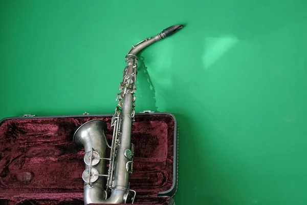Gammal Saxofon Lutade Sig Mot Grön Vägg — Stockfoto