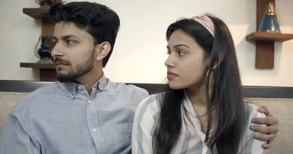 一对年轻的印度夫妇 坐在沙发上 神情严肃地把目光投向一边 — 图库照片