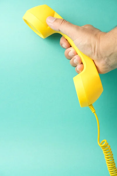Egy Retró Sárga Telefon Vevő Kezében Egy Kéz Egy Türkiz — Stock Fotó