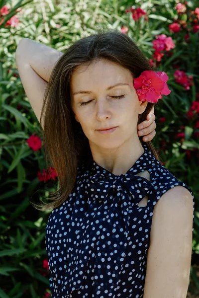 Вертикальный Снимок Белой Женщины Позирующей Саду Розовым Цветком Волосах — стоковое фото