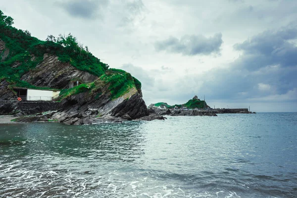 曇りの日の下で美しい岩の島と部分的に穏やかな海の自然の景色 — ストック写真