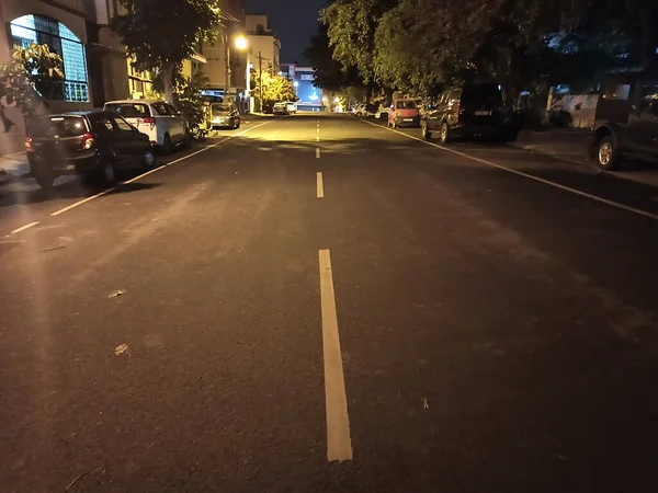 Widok Pustą Drogę Miejską Przyciemnionym Oświetleniem Nocy Samochodami Zaparkowanymi — Zdjęcie stockowe