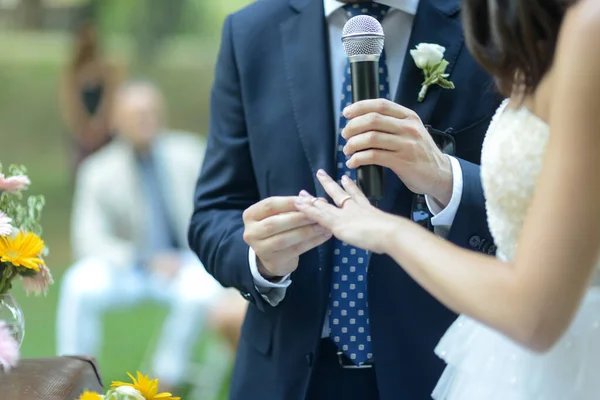 新郎と幸せな結婚式屋外で彼の花嫁の指にリングを置く — ストック写真