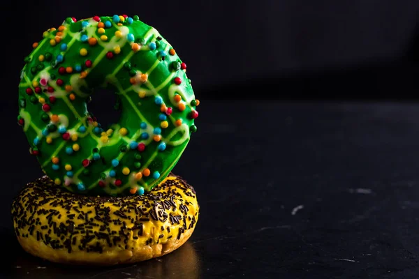Die Süßen Glasierten Donuts Mit Streusel Isoliert Auf Schwarzem Hintergrund — Stockfoto