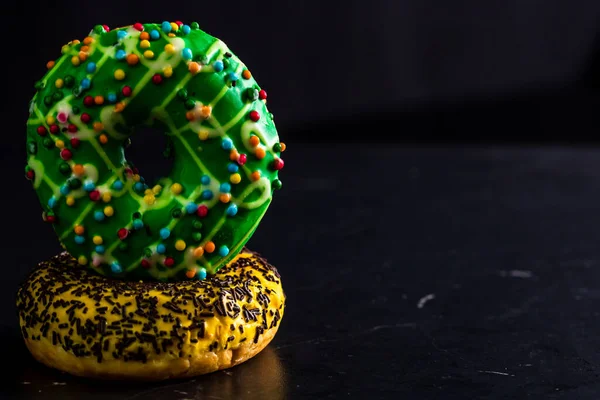 Las Rosquillas Acristaladas Dulces Con Aspersiones Aisladas Sobre Fondo Negro —  Fotos de Stock