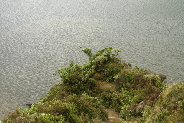 Воздушный Снимок Покрытых Деревьями Скал Над Прекрасным Озером — стоковое фото