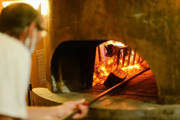 意大利米尼亚诺一位意大利厨师正在用木柴做传统的铜烤箱 — 图库照片