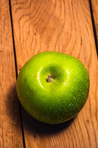 Ein Einziger Grüner Saftiger Grüner Apfel Auf Einem Hölzernen Hintergrund — Stockfoto
