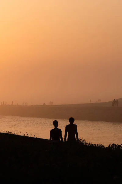 Une Silhouette Deux Jeunes Hommes Assis Sur Une Herbe Bord — Photo