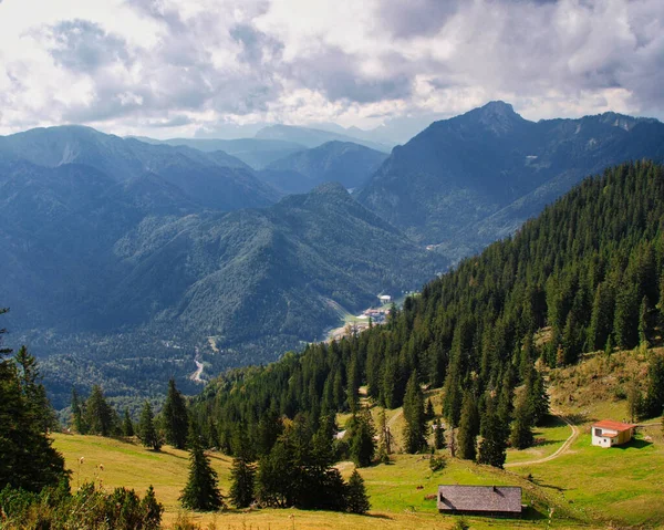 Ett Landskap Steniga Berg Täckt Grönska Solljuset Och Molnig Himmel — Stockfoto