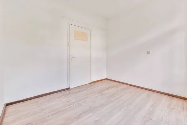 一间有白色墙壁和木制地板的空房间 — 图库照片