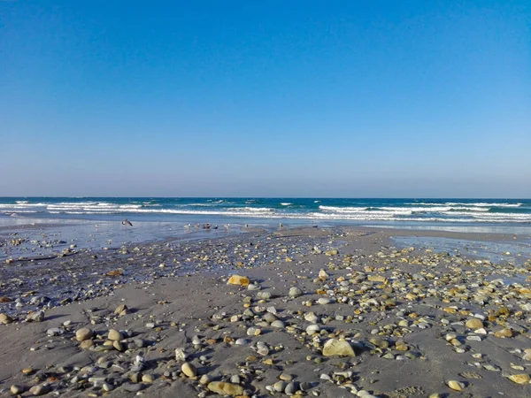 Piękny Słoneczny Dzień Plaży Pokrytej Skałami Pod Błękitnym Niebem — Zdjęcie stockowe
