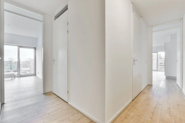两个房间之间的走廊 有白色墙壁和木制地板的房间 — 图库照片