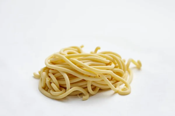 鮮やかな白い背景に配置された新鮮な調理されていないスパゲティ生地の閉鎖 — ストック写真