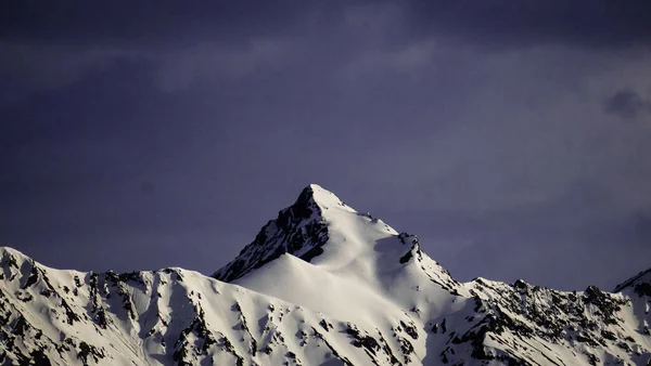 Bulutların Altında Buzla Kaplı Bir Dağ Zirvesi — Stok fotoğraf