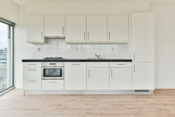 Uma Cozinha Com Mobiliário Branco Piso Madeira — Fotografia de Stock